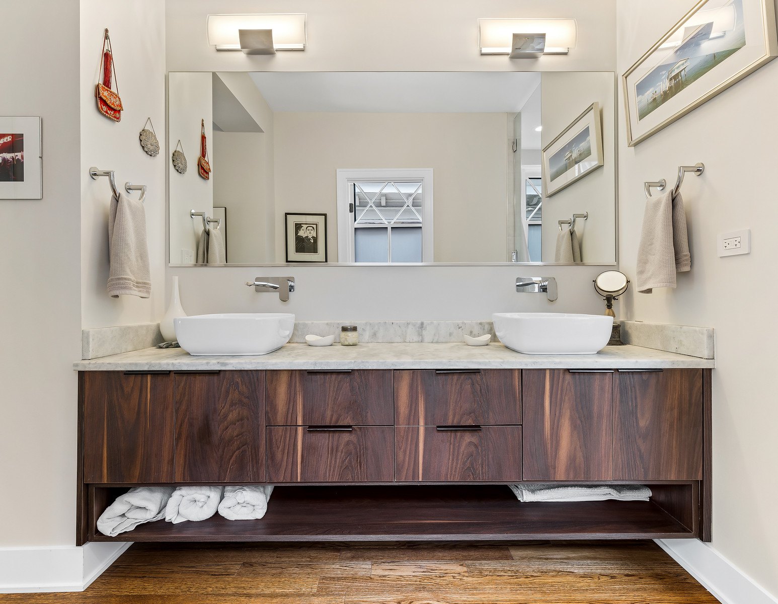 Finished walnut double vanity with a light natural-stone top and two vessel sinks