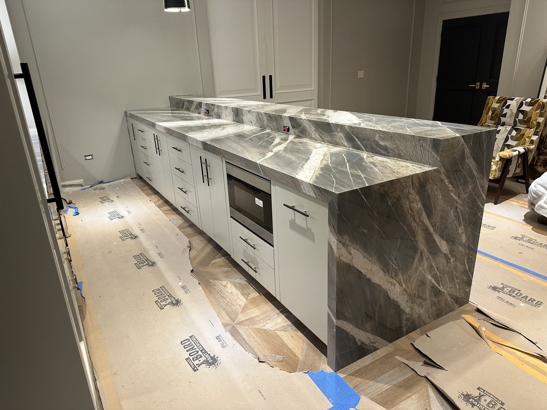 Reverse view of a layered gray stone island during installation