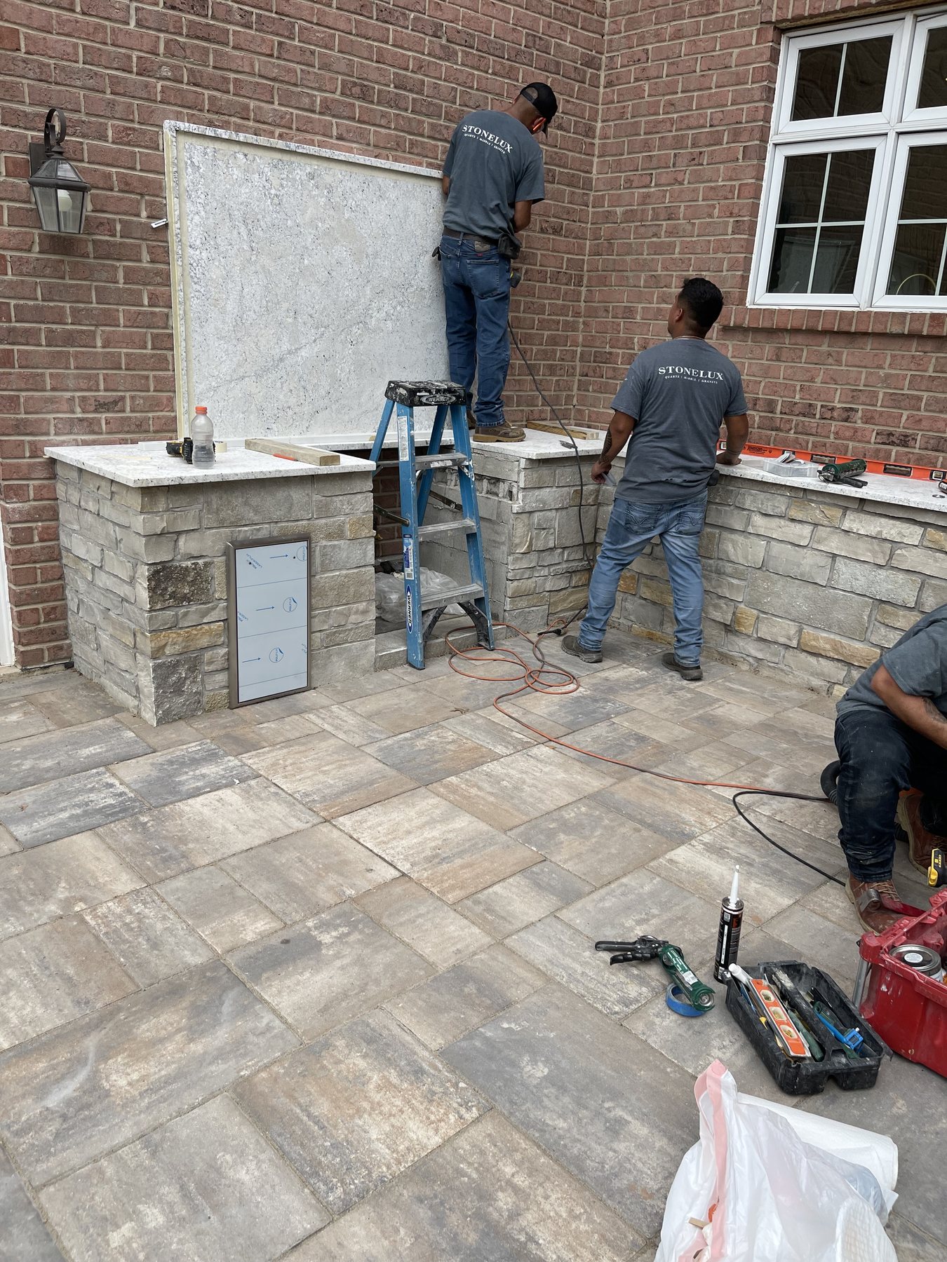 STONELUX installers setting stone on an outdoor masonry structure